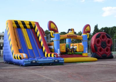 Patio de colegio con tres grandes estructuras hinchables (toboganes y castillos) organizadas por Inna Global en Madrid.