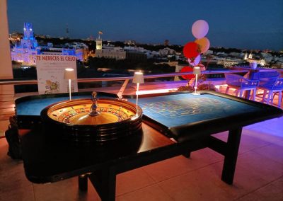 Mesa de ruleta profesional en evento corporativo nocturno en azotea con vistas a Madrid