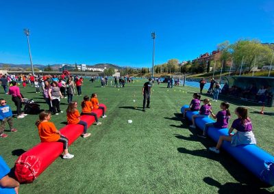 Gran pista de obstáculos hinchable de colores instalada en el patio de un colegio para una jornada deportiva de fin de curso