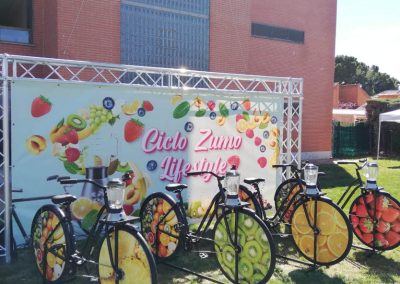 Bicicletas estáticas con batidoras integradas para taller infantil de elaboración de zumos naturales mediante el pedaleo en un colegio.