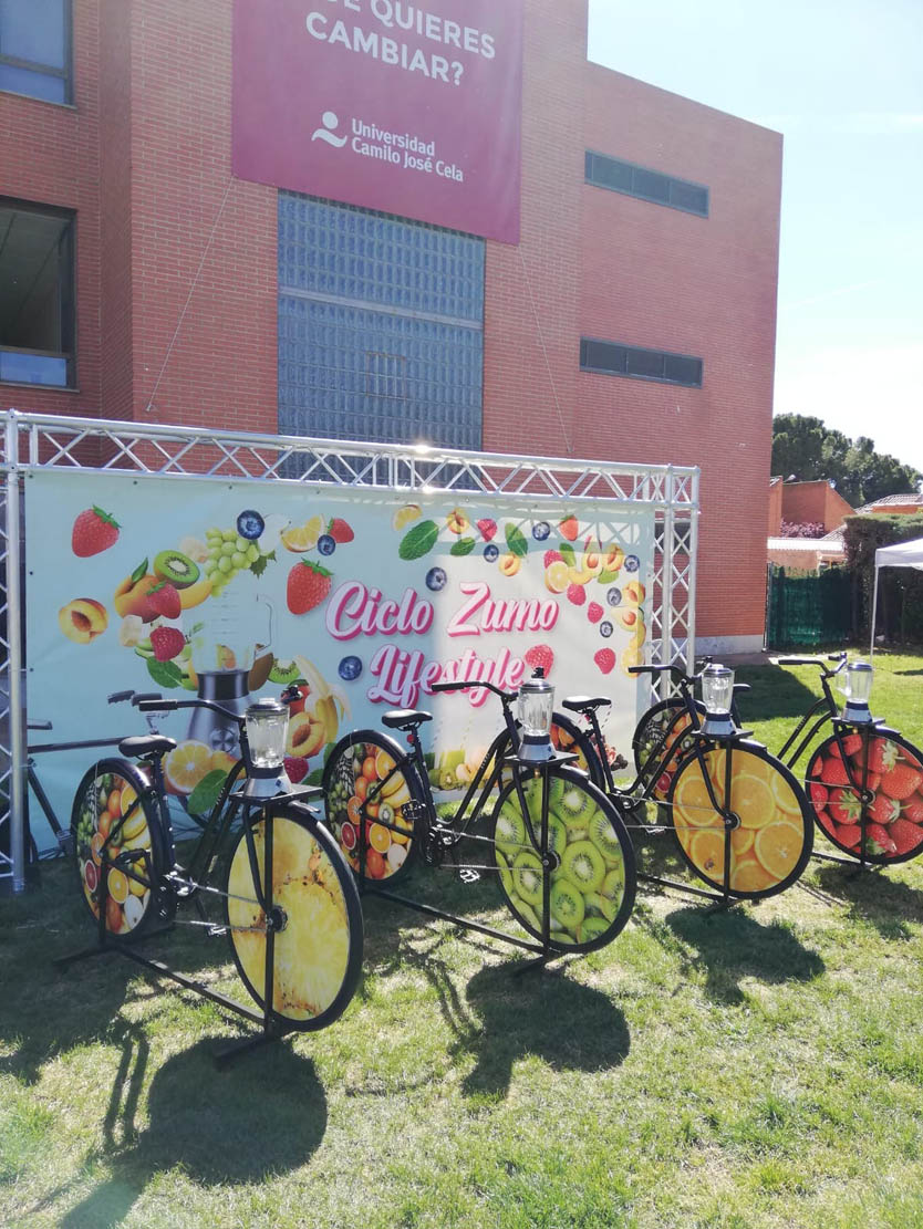 Bicicletas estáticas con batidoras integradas para taller infantil de elaboración de zumos naturales mediante el pedaleo en un colegio.
