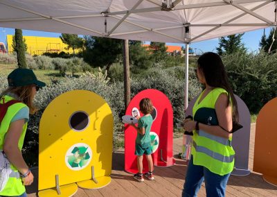 Actividad educativa con contenedores de colores para enseñar reciclaje a alumnos de primaria en un colegio de Madrid.